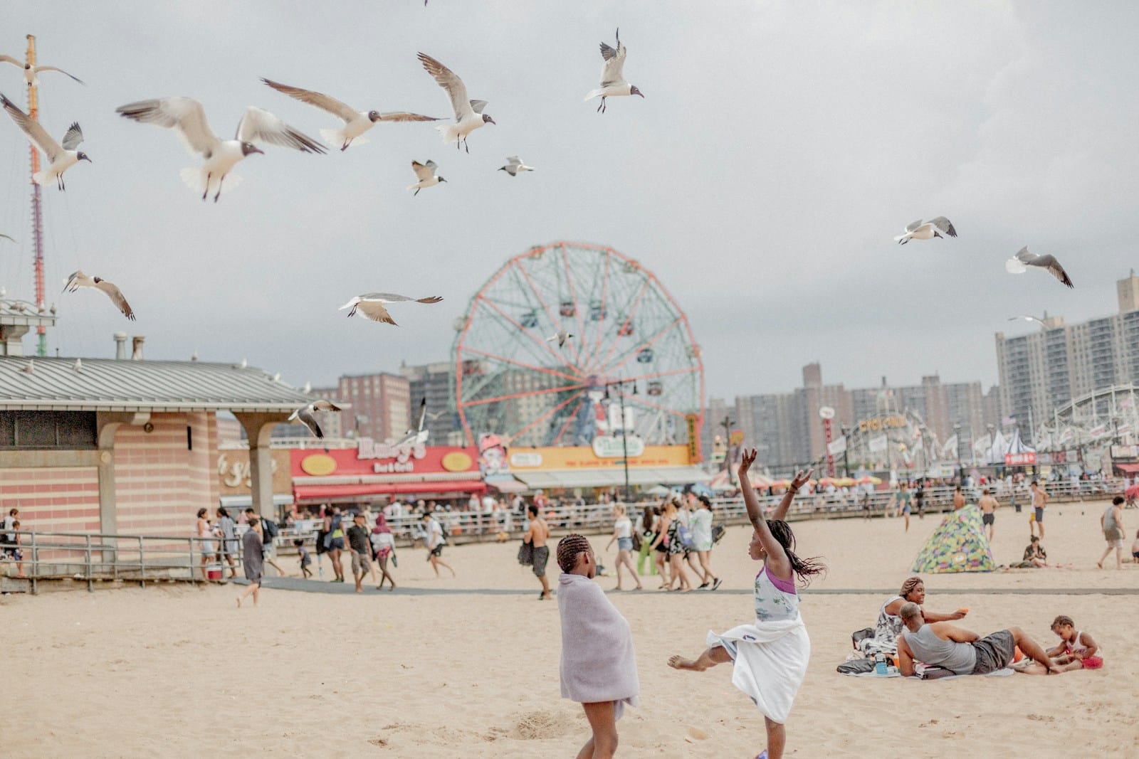 Plage animée, enfants, mouettes volantes, grande roue.