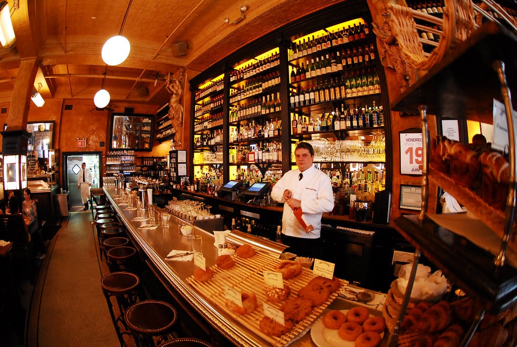 Bar bien approvisionné avec serveur et éclairage chaud.