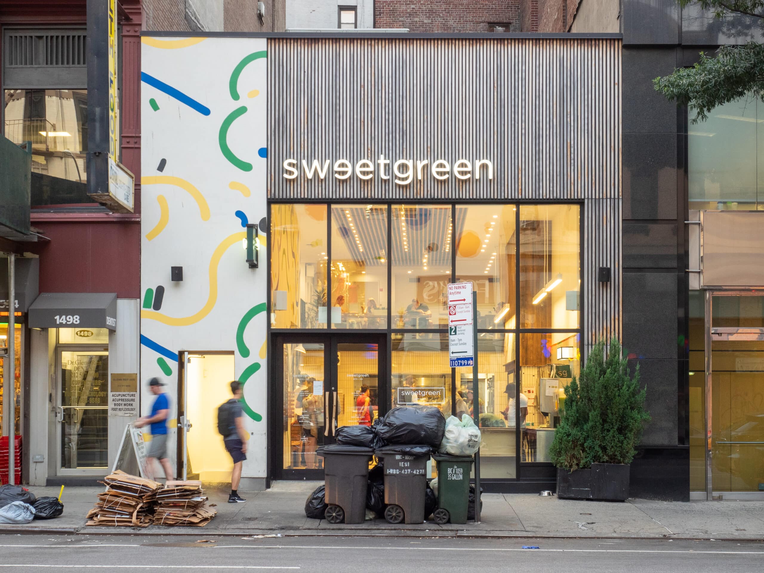 Façade du restaurant Sweetgreen avec décoration murale.