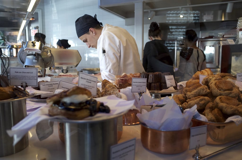 Chef préparant des pâtisseries dans une boulangerie moderne.