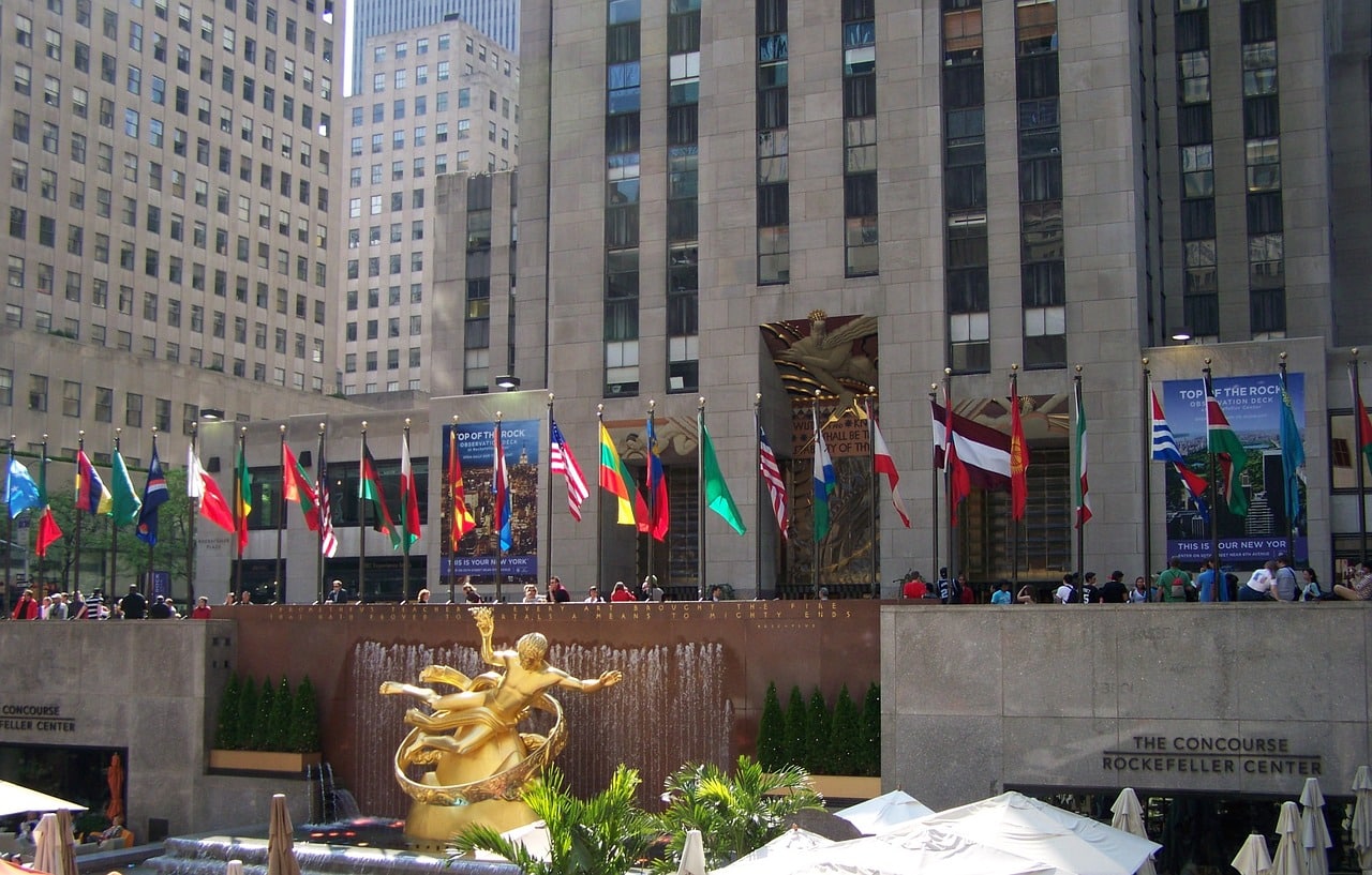 Rockefeller Center avec statues dorées et drapeaux internationaux.