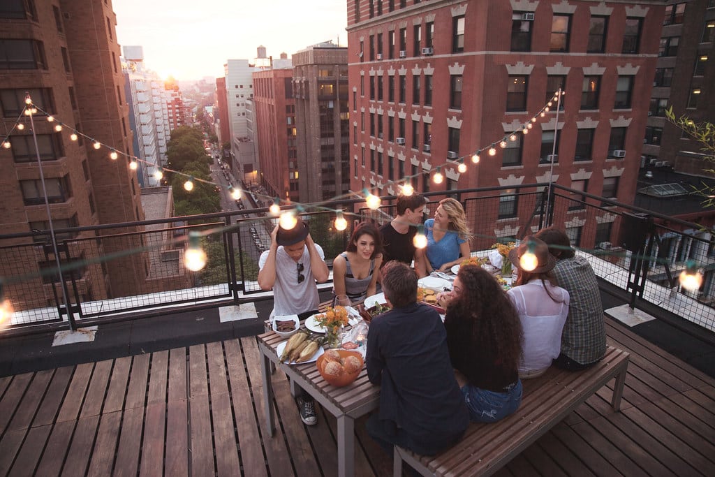 Dîner entre amis sur un toit urbain au crépuscule.