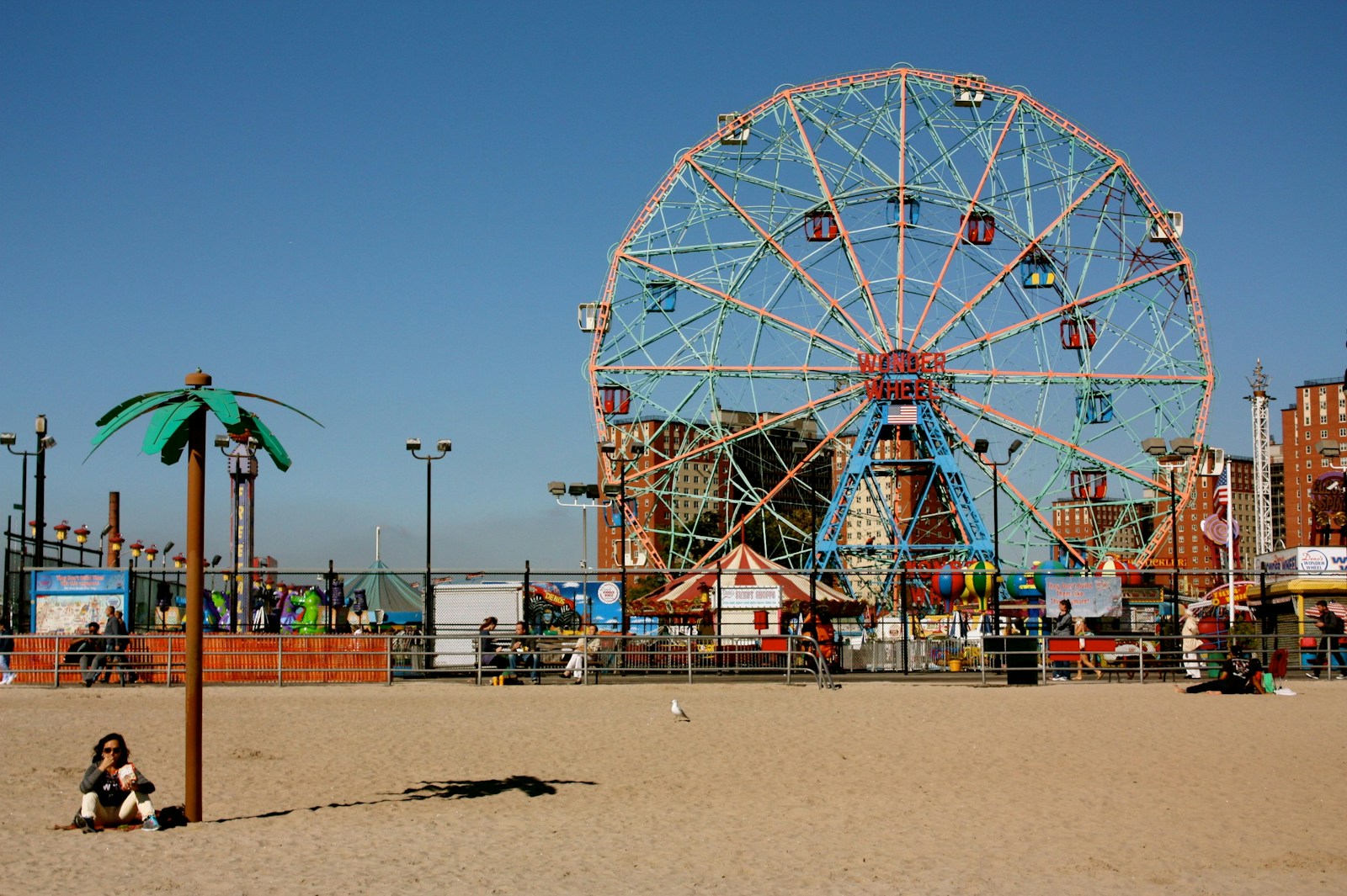 Grande roue colorée sur plage animée.