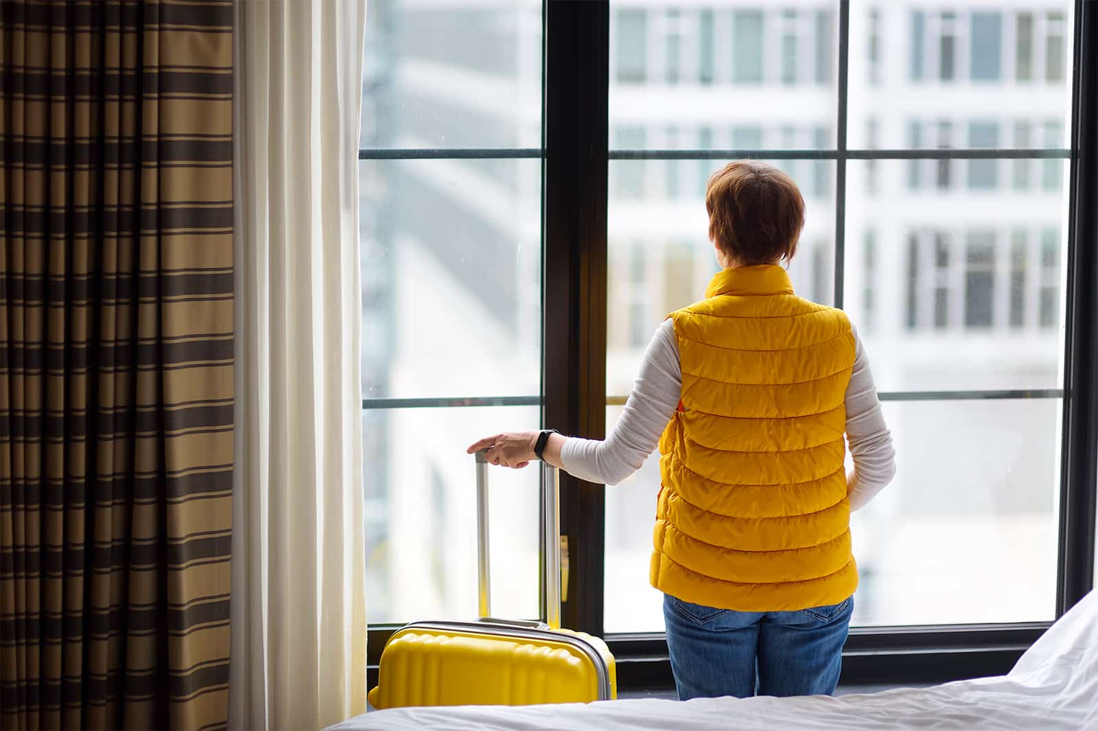 Femme observant par fenêtre d'un hôtel à new york